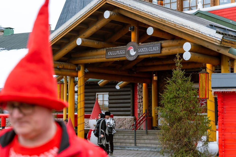Joulupukin luokse vievän pääsisäänkäynnin luona kaksi turistia seisomassa.