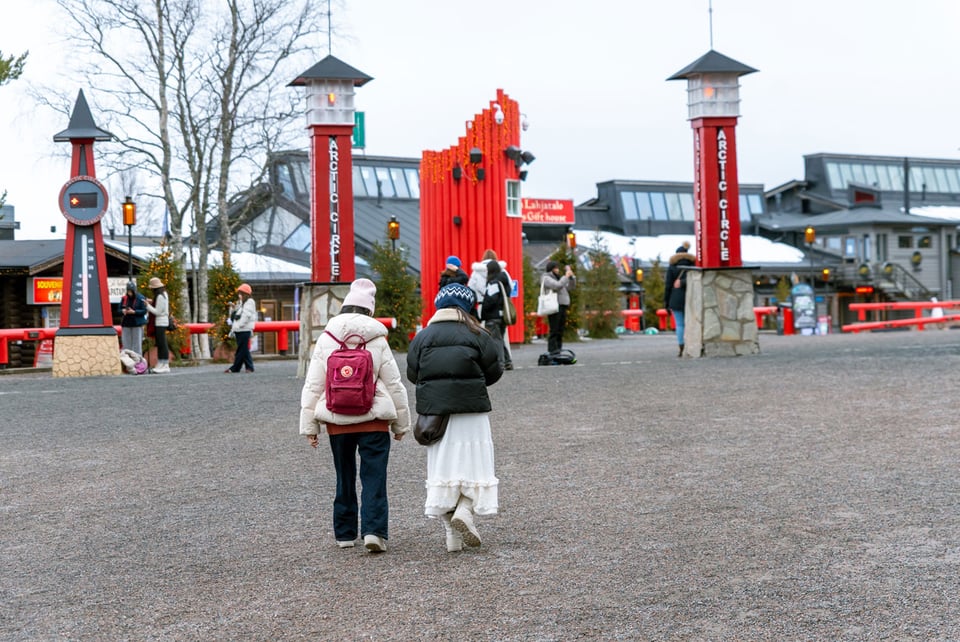 Turistit kuvaamassa Pajakylän aukiolla.